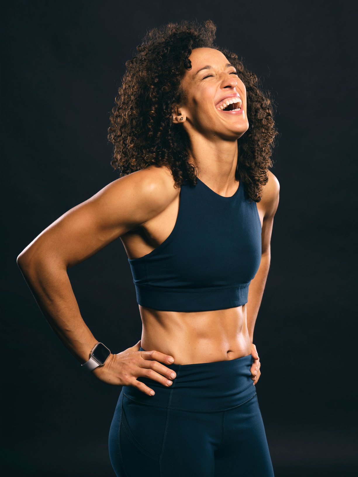 Portrait of Happy Fit Woman on Black Background